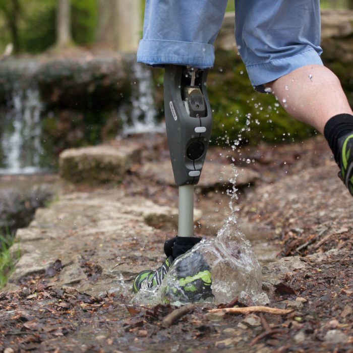 Mann läuft mit Beinprothese im Wald durch eine Pfütze